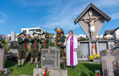 Pfarrer Giovanni Prietl vor dem neu renovierten Friedhofskreuz